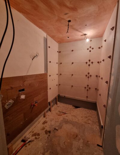 Salle de bain avant finition avec murs en préparation, installations en cours et chantier non terminé.